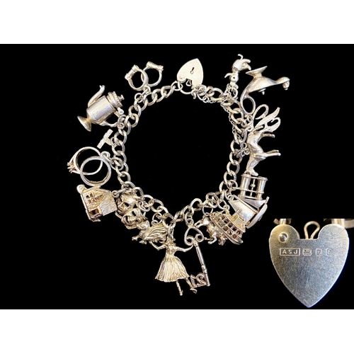 388 - Silver Charm Bracelet Loaded with Different Charms, Includes a Key, Jug, Horse, Sailing Boat, Duck, ... 