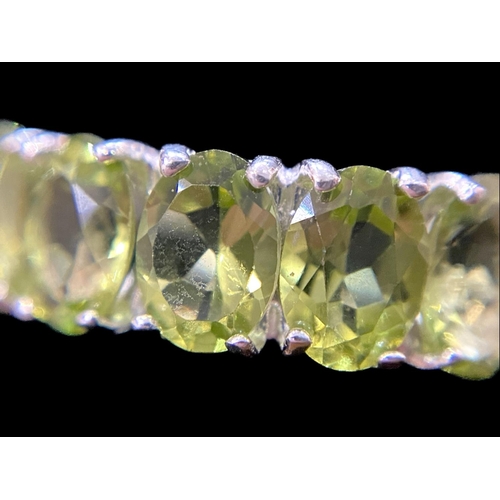 310 - Peridot Half Eternity Ring, five oval cut, bright, sparkling peridots, totalling 4cts, closely set i... 