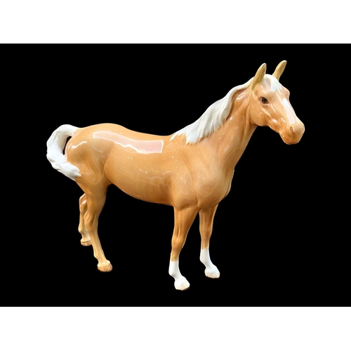 517 - Beswick Palomino Horse Figure, facing right, swish tail and gloss finish, together with a Beswick da... 