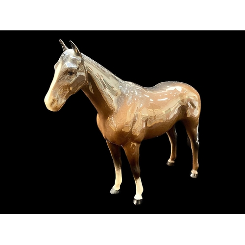 517 - Beswick Palomino Horse Figure, facing right, swish tail and gloss finish, together with a Beswick da... 