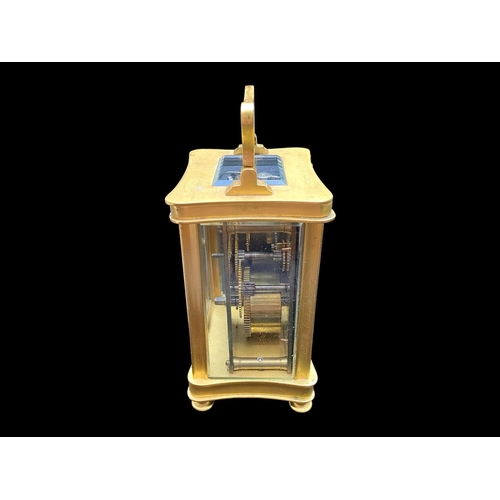 1103 - A Small Brass Carriage Clock of typical form, white enamel dial and Roman numerals. Height 4½ inches... 