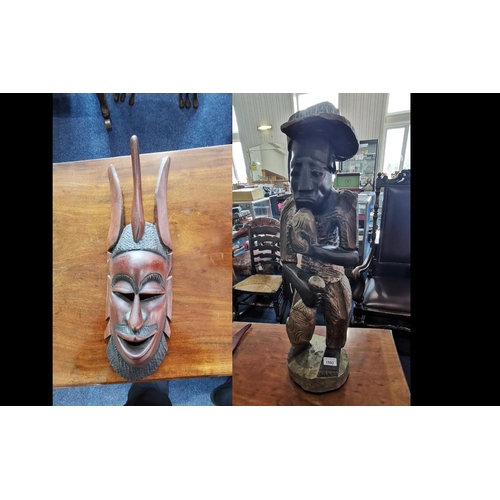 1592 - Two Wooden African Carvings, comprising a large African man holding a fish, measures 26'' high.  Tog... 