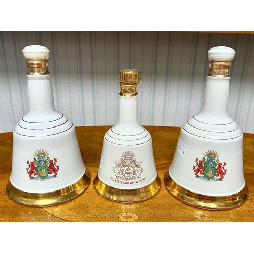 1370 - Three Bell's Scotch Whisky Commemorative Porcelain Decanters, two 75cl decanters celebrating the mar... 