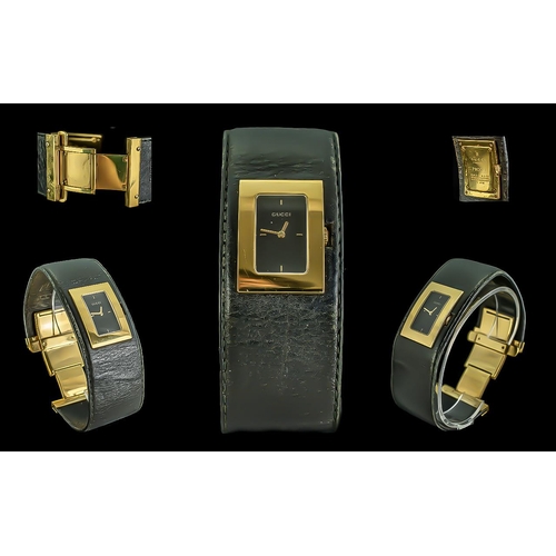 129 - Gucci Ladies Excellent Gold on Steel Quartz Black Leather Banded Fashion Watch, with fold-over deplo... 