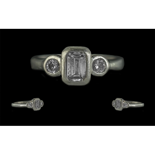 60A - Platinum & Diamond Ring, set with an emerald cut centre stone with two round brilliant cut, fully ha... 