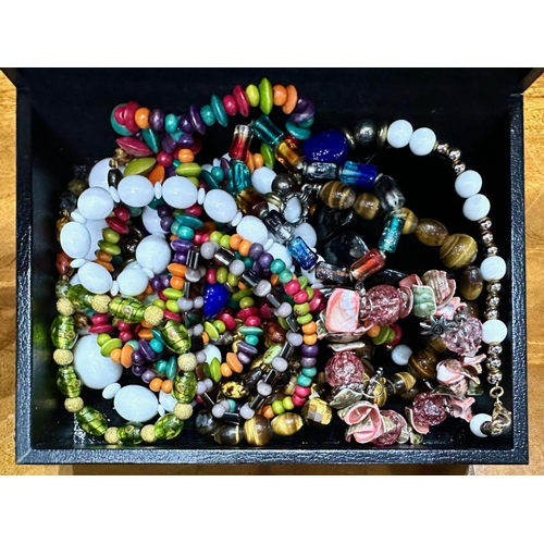 467A - Box of Costume Jewellery, comprising assorted coloured beads, bracelets, etc., housed in a black lea... 