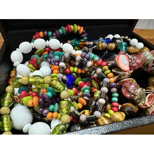 467A - Box of Costume Jewellery, comprising assorted coloured beads, bracelets, etc., housed in a black lea... 