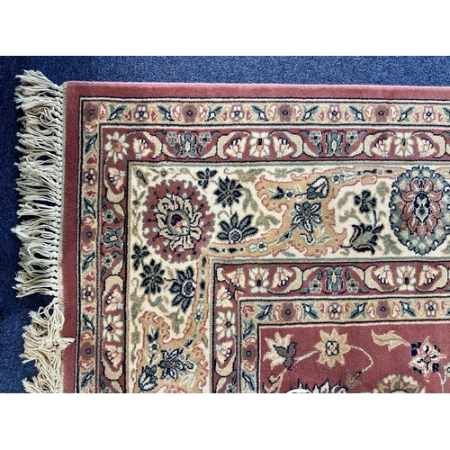 1038 - Large Royal Keyshan Wool Carpet, pink background with floral border and fringing, (some marks), meas... 