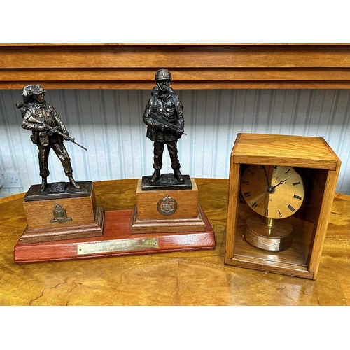 1352 - Military Interest A Presentation Clock housed in a wooden box. Together with a trophy of two armed s... 