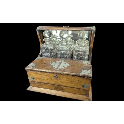 1055 - Vintage Wooden Tantalus with three decanters, two front compartments, and brass decoration.