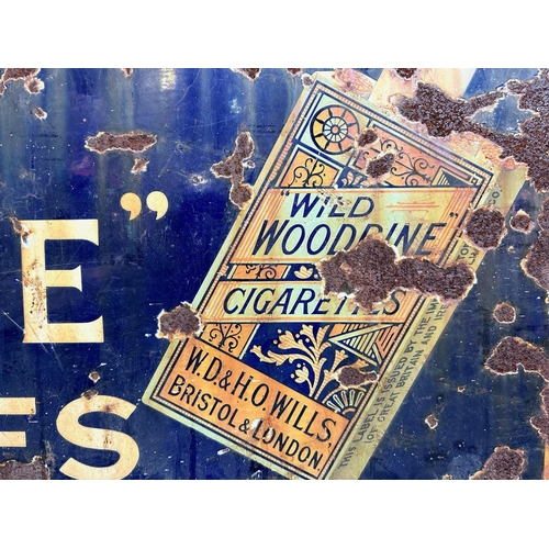 1356 - Cast Iron Enamel Sign 'Wild Woodbine Cigarettes', as found condition.  Measures 18'' x 48''.  Looks ... 