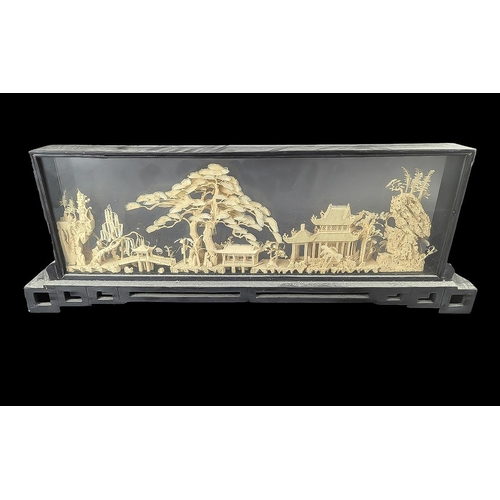 847 - Oriental Free Standing Carved Cork Framed Scene, depicting houses, trees and birds.  Framed in a bla... 