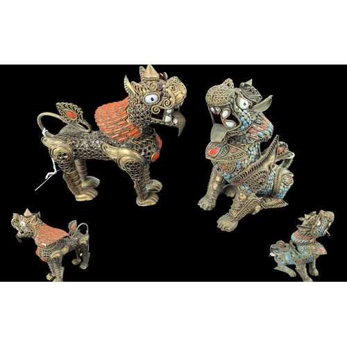 819 - Two Oriental Figures - Temple Dogs, base metal set with jewel adornments.  7'' high.