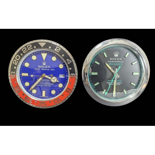 1106 - Two Rolex Style Dealer Display Wall Clocks, comprising one with a black face, date aperture, silver ... 