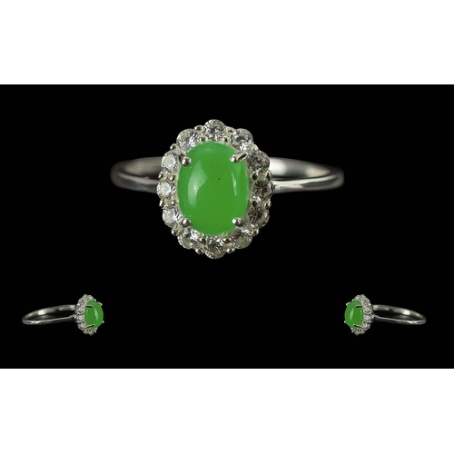 296 - Chinese Jade and Cambodian Zircon Ring, a classic style with a green jade oval cabochon, framed with... 