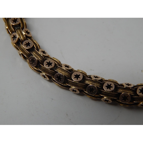 22 - Yellow Metal Bracelet of ringed construction with star cut roundels with safety chain. 20cm long. 15... 