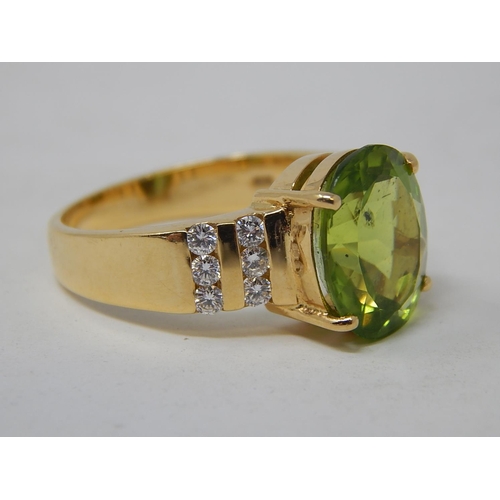 26 - Peridot & Diamond Ring. The Large Oval Peridot estimated weight 4.85cts with two rows of round brill... 