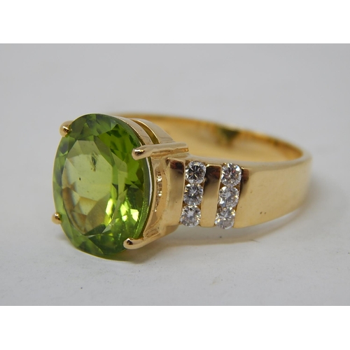 26 - Peridot & Diamond Ring. The Large Oval Peridot estimated weight 4.85cts with two rows of round brill... 