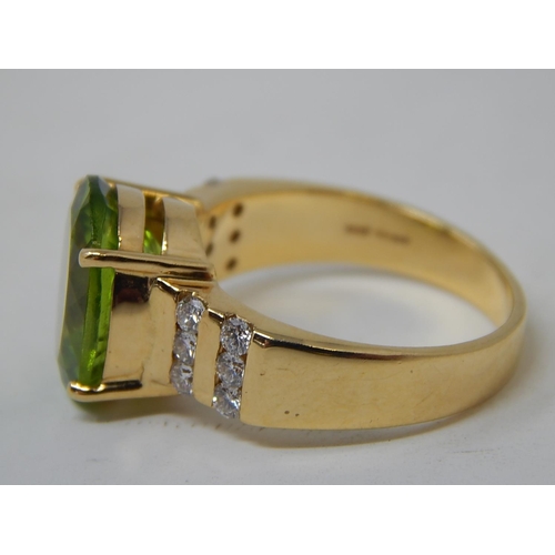 26 - Peridot & Diamond Ring. The Large Oval Peridot estimated weight 4.85cts with two rows of round brill... 