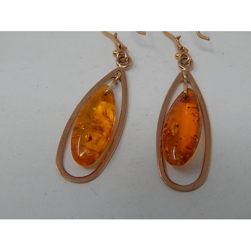 41 - A Pair of Amber drop earrings mounted in 14ct Rose Gold.