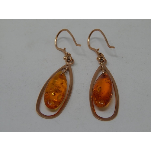 41 - A Pair of Amber drop earrings mounted in 14ct Rose Gold.