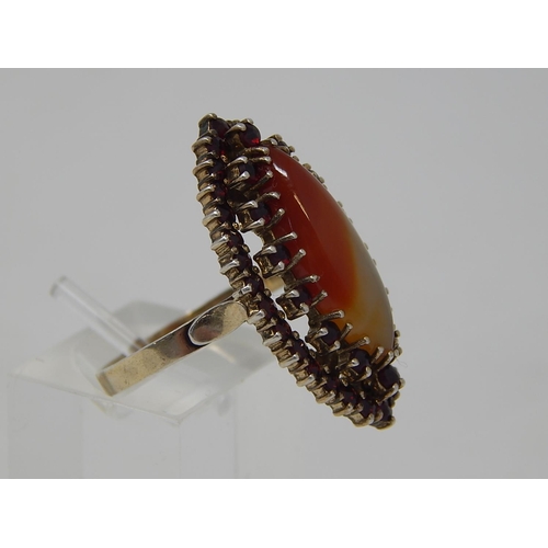 69 - Silver Gilt Ring, set central Agate with a Garnet Border. Ring size Q 1/2.