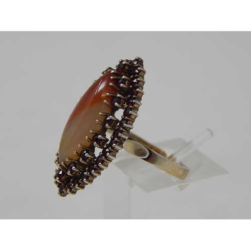 69 - Silver Gilt Ring, set central Agate with a Garnet Border. Ring size Q 1/2.