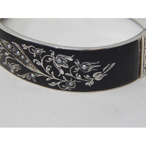 76 - A Silver Black Enamelled & Seed Pearl Mourning Bangle.