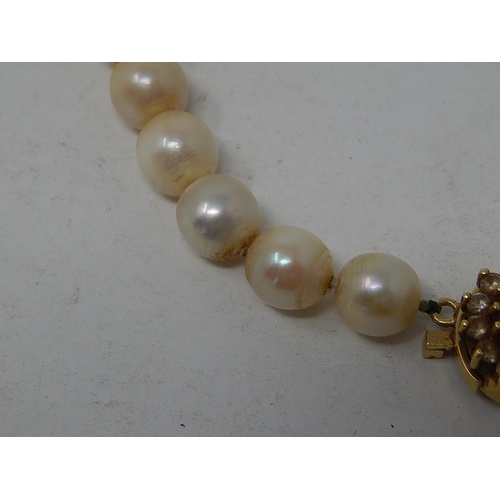 102 - Pearl Necklace With an 18ct Gold Clasp set with a central pearl & Diamond border. Length 40cm.