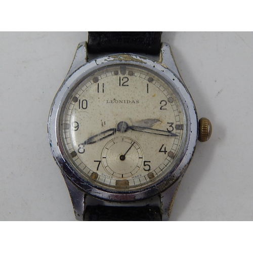 222 - Military: Gents Leonidas wristwatch, marked with broad arrow to back on leather strap.