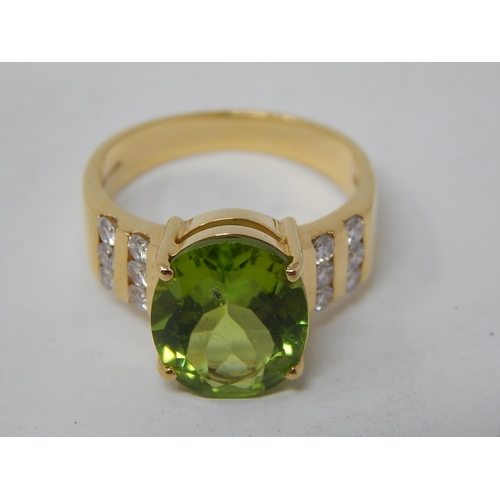 22 - Peridot & Diamond Ring. The Large Oval Peridot estimated weight 4.85cts with two rows of round brill... 