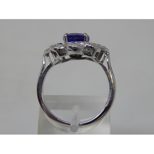 102 - Tanzanite and diamond cluster ring, central round cut tanzanite with a surround of round brilliant c... 