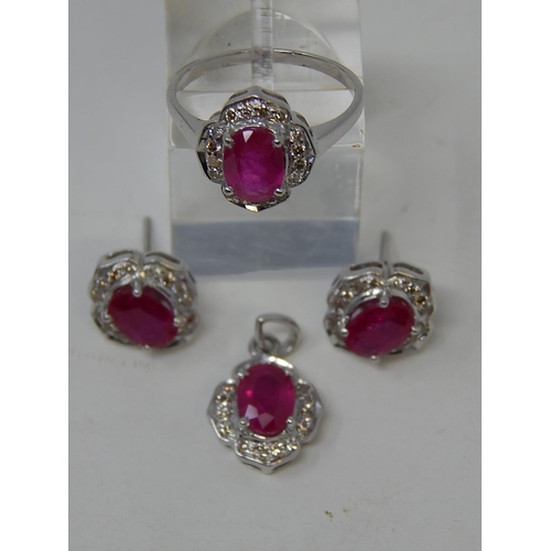 110 - Ruby and diamond pendant, ring and earring set, each item set with an oval cut ruby and a surround o... 