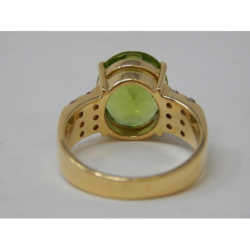 118 - Peridot & Diamond Ring. The Large Oval Peridot estimated weight 4.85cts with two rows of round brill... 