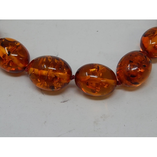 141 - Amber Necklace with 9ct Gold clasp. Measures 70cm Long.