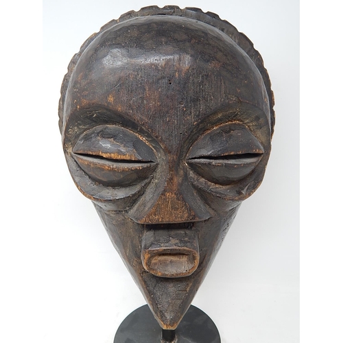 350 - Tribal Mask carved from one piece of wood on later Metal Stand: Measures 31cm high