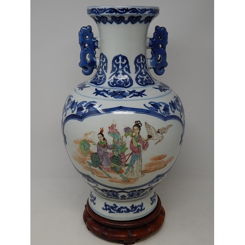 385 - Chinese blue and white porcelain vase, with twin handles raised on hardwood stand, the two central p... 