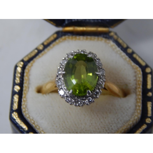 148 - Peridot and diamond cluster ring, oval cut peridot weighing an estimated 2.10cts, with a surround of... 