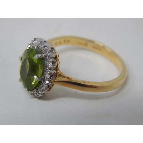 148 - Peridot and diamond cluster ring, oval cut peridot weighing an estimated 2.10cts, with a surround of... 