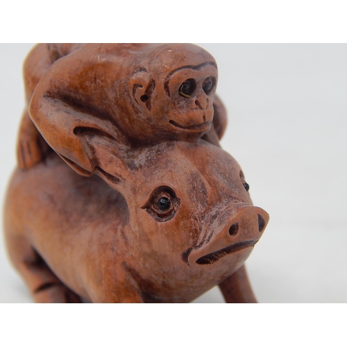 485 - CHINESE: Carved Wood Neksuke of a Monkey riding a Pig: Measures 5.4cm High