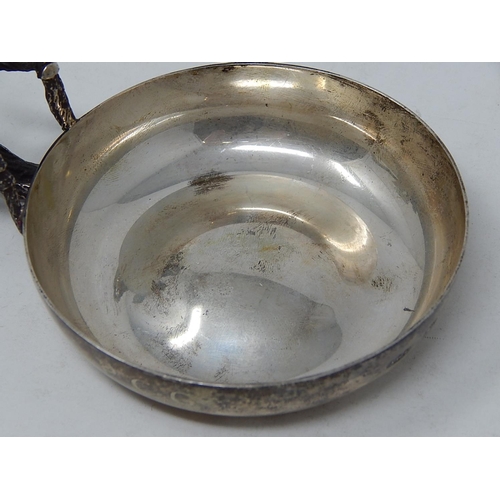 28 - ANTHONY ELSON: Silver Tastevin with naturalistic handle formed as branches complimenting a plain cir... 