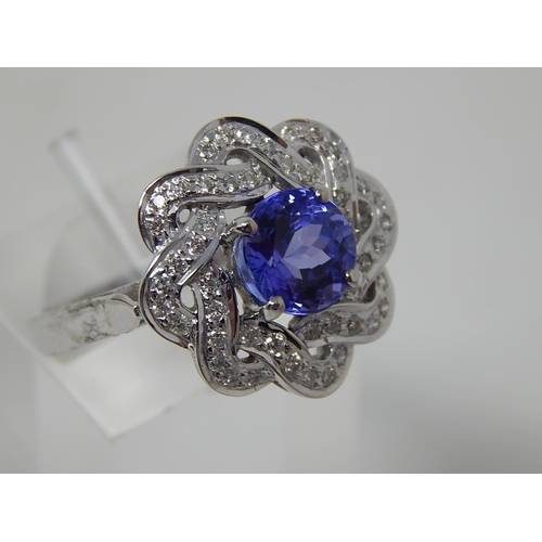 57 - Tanzanite and diamond cluster ring, central round cut tanzanite with a surround of round brilliant c... 