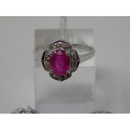 75 - Ruby and diamond pendant, ring and earring set, each item set with an oval cut ruby and a surround o... 