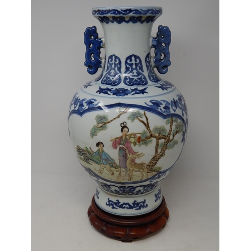 125 - Chinese blue and white porcelain vase, with twin handles raised on hardwood stand, the two central p... 