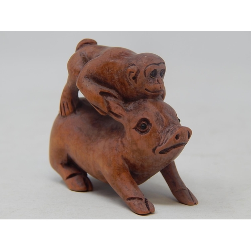 135 - CHINESE: Carved Wood Neksuke of a Monkey riding a Pig: Measures 5.4cm High