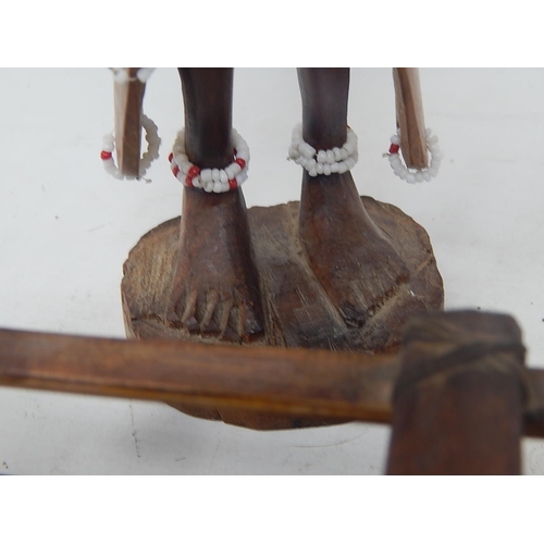 561 - Tribal Carved Wooden Figure 31cm: together with Two carved Wooden Boats 44cm & 37cm