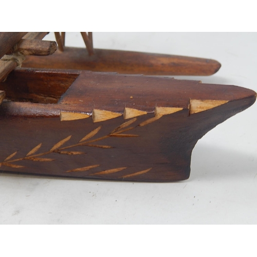 561 - Tribal Carved Wooden Figure 31cm: together with Two carved Wooden Boats 44cm & 37cm