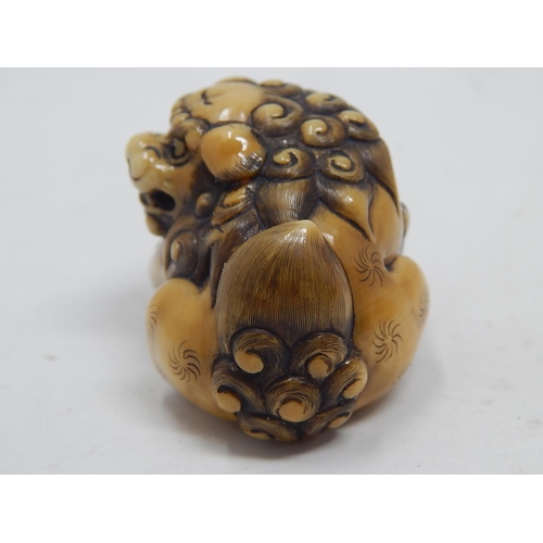 153 - Japanese Signed Netsuke of a Shishi, Foo Dog resting on the ball of life: Edo/Meiji Period: Measures... 