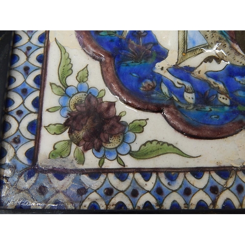 324 - Qajar moulded polychrome pottery tile.
Moulded and painted in underglaze blue, green & mauve depicti... 