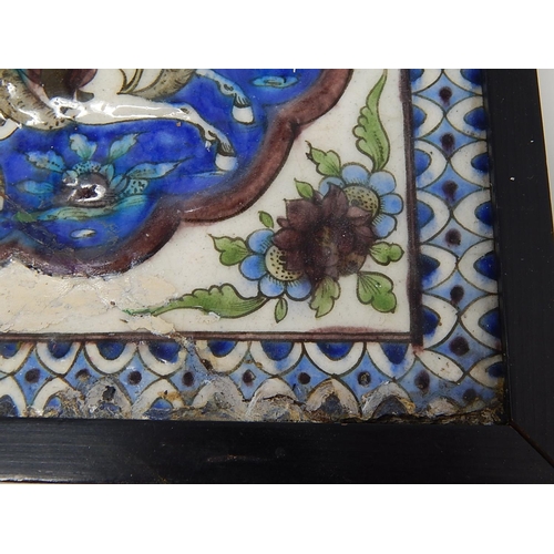 324 - Qajar moulded polychrome pottery tile.
Moulded and painted in underglaze blue, green & mauve depicti... 